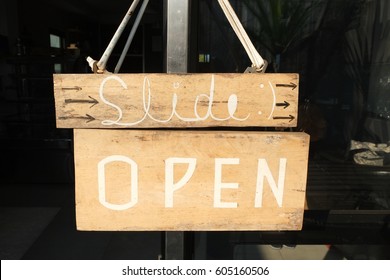 Open wooden board sign hanging glass door in front the restaurant