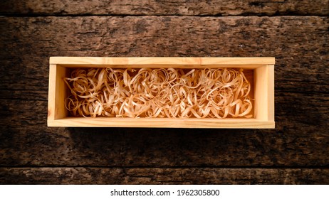 Open wooden box for vine filled with shreded paper. empty wooden crate with shavings for a bottle of wine on an old wooden table