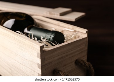 Open Wooden Crate With Bottle Of Wine On Dark Background, Closeup