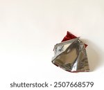 open wrapper and see the silver color inside isolated on white background. Texture of used crumpled aluminium food foil.