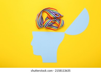 Open Your Mind, Mental Health Concept, Creative Thinking. Paper Silhouette Of Human Head And Lgbt Rainbow Tape On Yellow Background