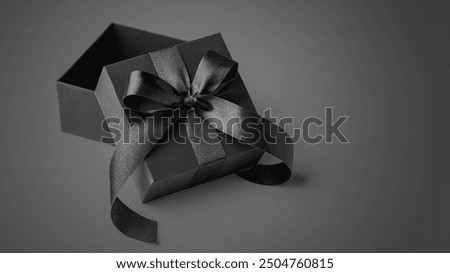 Opened black gift box with bow, black friday sale background, copy space