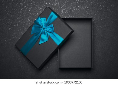 Opened Black Gift Box With A Red Ribbon And A Large Bow On A Dark Granite Surface. Empty Box. Mockup