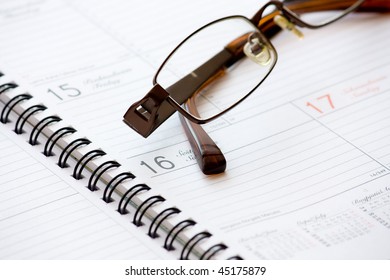 Opened blank notebook and spectacles
