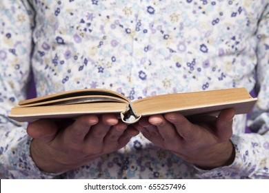 the opened book is in the hands of the guy