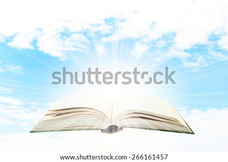 Opened book on sky background