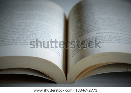 Opened book on the table. Intentionally blurred image, out of focus. Vignetting photo effect