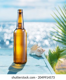 Opened bottle of beer with condensation on the wooden table. Blurred sparkling sea at the background. Summer vibes. - Shutterstock ID 2049914573