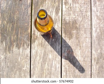 Opened Brown Beer Bottle With Long Shadow On Wodden Boards Floor