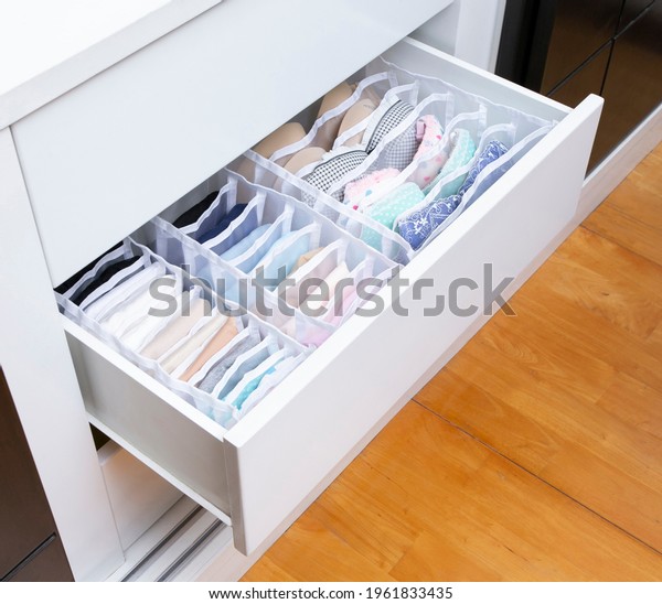 The opened closet drawer with fabric boxes\
for separate storage of bra and\
underwear.