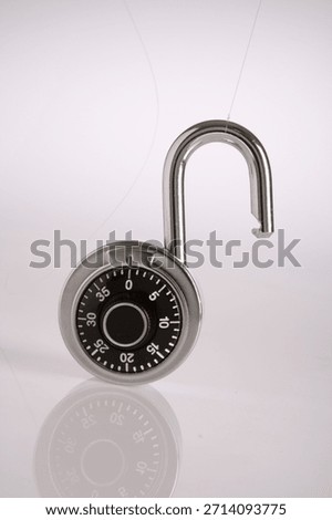 Opened combination padlock with dial showing zero, chrome and black, on white background