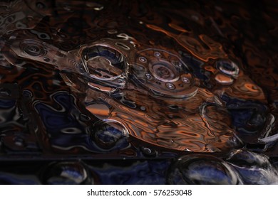 Opened Computer hard disk drive in studio with bubbles and dark red and blue reflection, conceptual creative association