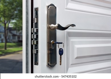 Porta aberta de uma casa de família. Close-up da fechadura com as chaves em uma porta blindada. Segurança.