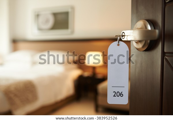 Opened door of\
hotel room with key in the\
lock