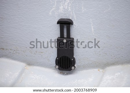 Opened drain scupper valve into the transom of a plastic RIB motor boat, preparing for navigation