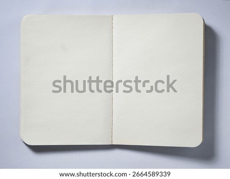 Opened empty book with white plain paper isolated on horizontal copy spaced white background from top angle view.