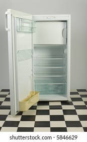 Opened, Empty Fridge, Standing On Black And White Floor. Front View