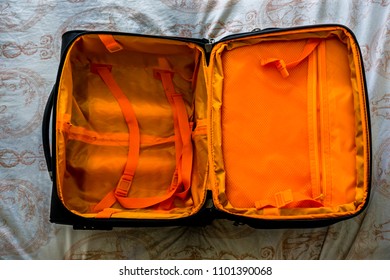 Opened Empty Travel Bag On The Bed. Large Open Fashionable Suitcase. Empty Luggage Ready For Being Full For Journey. Time To Go To Holiday. Holiday Preparation Concept. Top View Of Empty Suitcase.