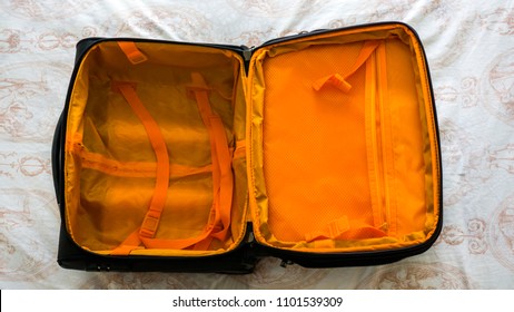 Opened Empty Travel Bag On The Bed. Large Open Fashionable Suitcase. Empty Luggage Ready For Being Full For Journey. Time To Go To Holiday. Holiday Preparation Concept. Top View Of Empty Suitcase.