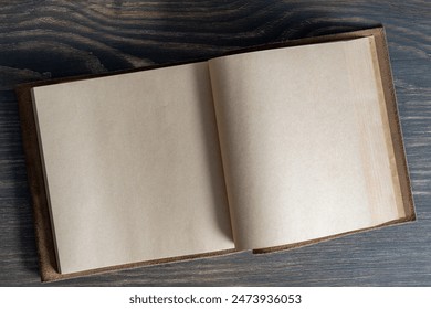 Opened empty vintage book in leather cover on wooden background, space for text, close up, top view, copy space - Powered by Shutterstock