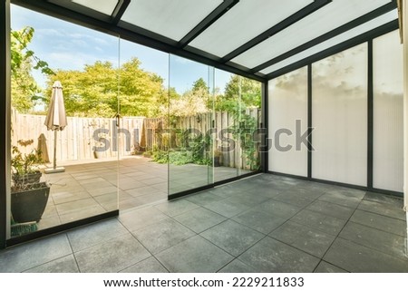 Opened glass door leading into terrace from stylish living room in modern light home