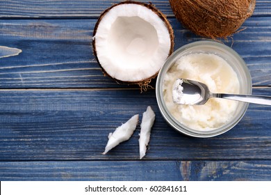 Opened glass jar with fresh coconut oil on wooden background - Shutterstock ID 602841611