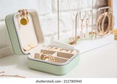 Opened jewelry box on table near white brick wall