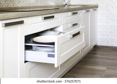 Opened kitchen drawer with plates inside, a smart solution for kitchen storage and organizing.  - Shutterstock ID 576257071