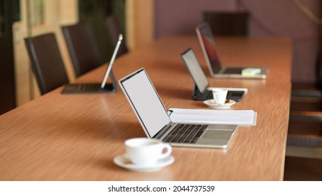 Opened Laptop Computer Stand On Wooden Conference Table In Modern Meeting Room