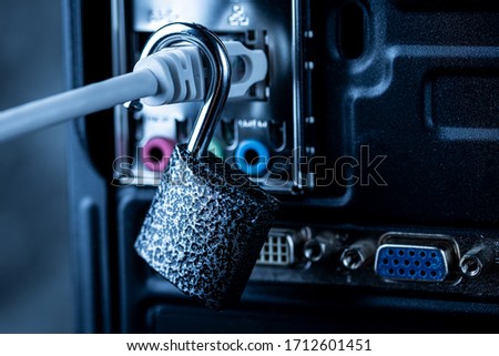 Opened lock hanging on a network cable plugged into a computer. The concept of opening access, unlocking the Internet or hacking anti-virus protection or firewall by hackers. Theft of personal data.