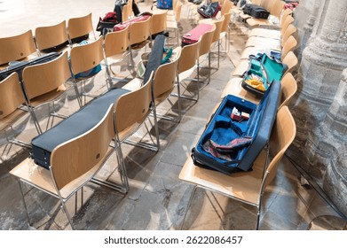 Opened musical string instrument cases seen on chairs within a famous English cathedral during a live practice session.