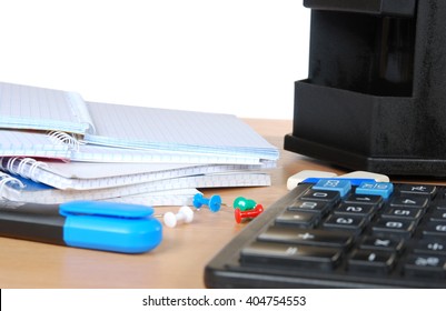 opened notebook with blue text marker, erasers and calculator on the table