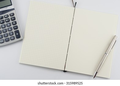 Opened notepad with pen and calculator on white background. - Shutterstock ID 315989525