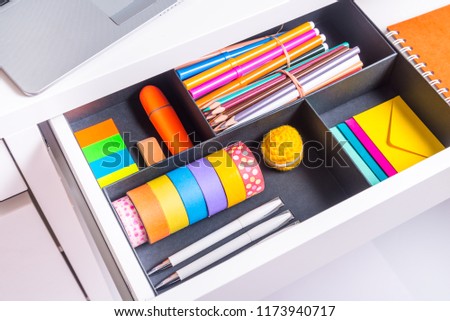 Opened office desk drawer with stationary 