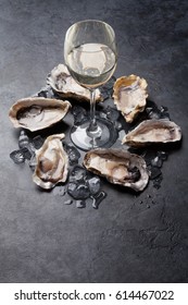 Opened oysters, ice and lemon and white wine on stone table