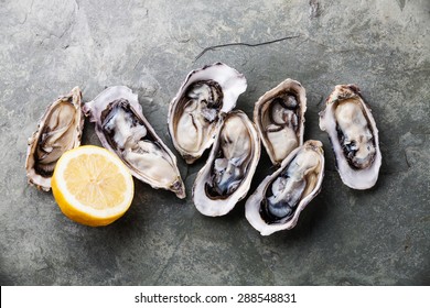 Opened Oysters on stone slate plate with lemon