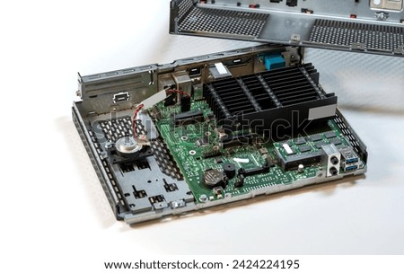 Opened passively cooled computer terminal, displaying showing internal parts, components. Motherboard, heatsink, and various connectors on display, desktop PC service and repair abstract concept