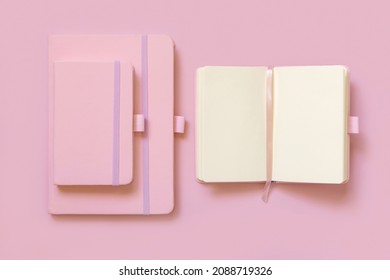 Opened Pink notebook near other two on light pink top view. Textbook mockup, planner cover with place fot text. Educational, business and organizing
