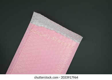 Opened Pink Plastic Bubble Envelope On Black Background