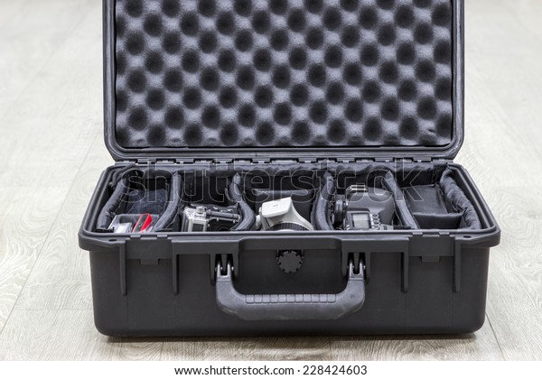 Opened\
plastic case with photo equipments in\
dividers