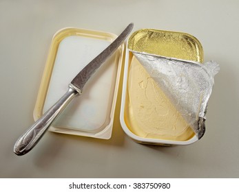 Opened Plastic Margarine Box With Half Removed Foil And Table Knife.        