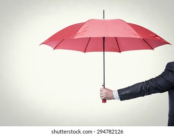 Opened red umbrella in hand, toned photo.