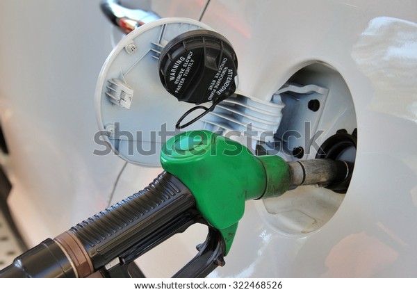Opened tank and gun of gas station.\
Fuelling gasoline in car. Shallow depth of\
field