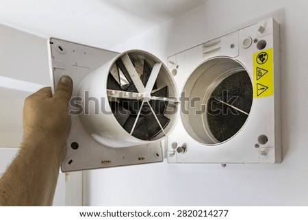 opened wall mounted recuperator ventilation unit during indoor maintenance and inspection.