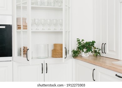 Opened White Glass Cabinet With Clean Dishes And Decor. Scandinavian Style Kitchen Interior. Organization Of Storage In Kitchen.	