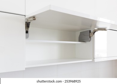 Opened White Kitchen Cabinet With Empty Shelf