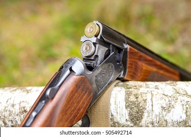 Opened wooden double-barreled hunting gun with two cartridges