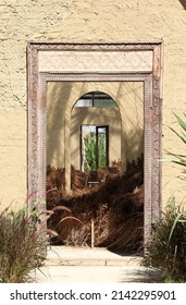 The Opened Wooden Front Door On The Yellow Concrete Wall.