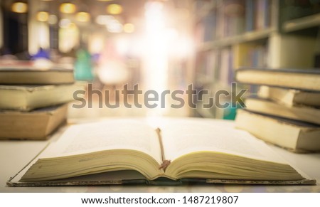 Opening book of Holy Bible with text on blurred cross background 
