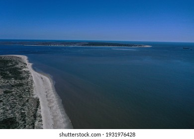 The Opening Of The Cape Fear River. Looking Down The Beach Coastline With Bald Head Island In The Distance.